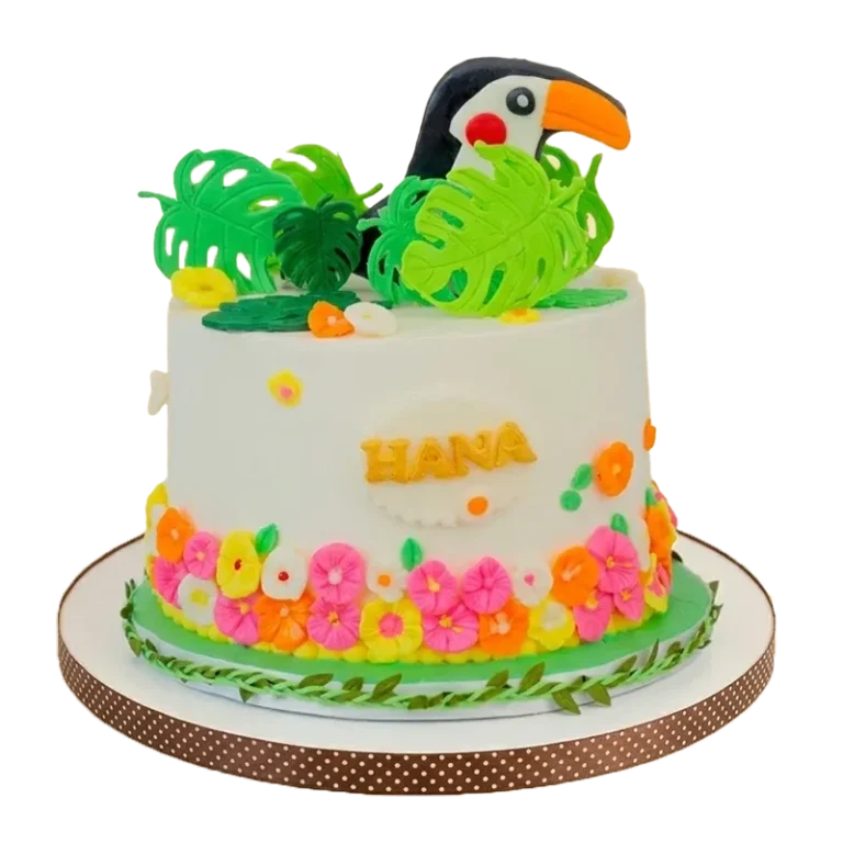 Tropical botanical birthday cake with toucan figure, monstera leaves, tropical flower border, and Hana inscription