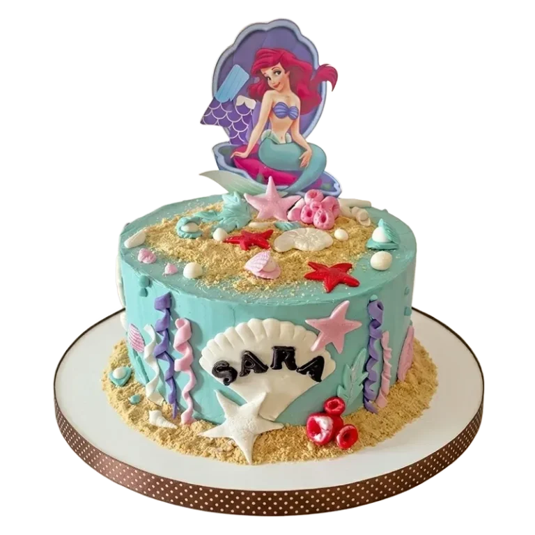 Teal Little Mermaid birthday cake with Ariel in clam shell topper, starfish, sand, and seaweed