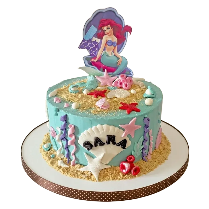 Teal Little Mermaid birthday cake with Ariel in clam shell topper, starfish, sand, and seaweed