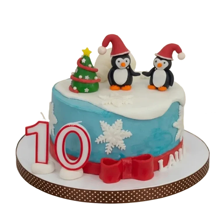 Blue winter birthday cake with penguin figures in Santa hats, Christmas tree, and snowflakes