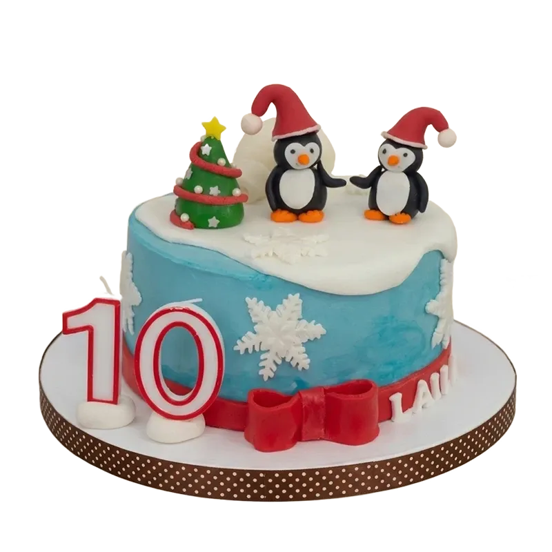 Blue winter birthday cake with penguin figures in Santa hats, Christmas tree, and snowflakes