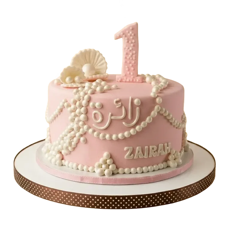 Pink first birthday cake with pearl strand draping, pearl clusters, clam shell, and name inscription