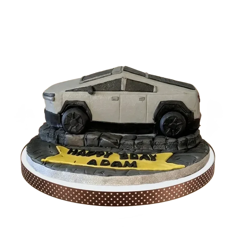 Tesla Cybertruck sculpted birthday cake on rocky terrain base with birthday inscription