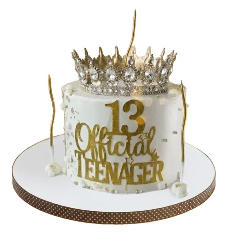 White 13th birthday cake with diamond crown topper and Official Teenager gold inscription