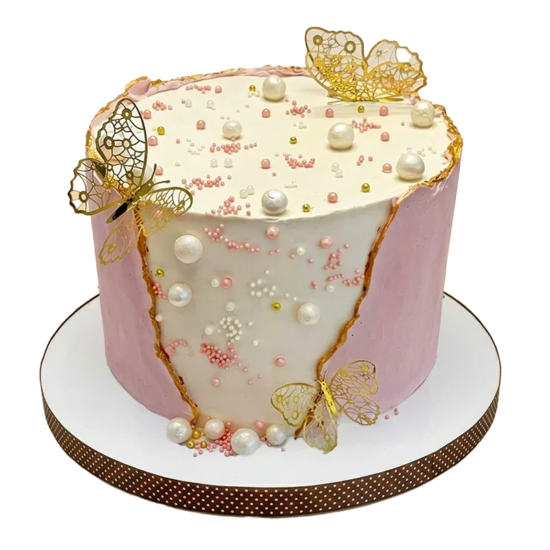 Pink and white birthday cake with gold filigree butterflies, white pearls, and gold veining