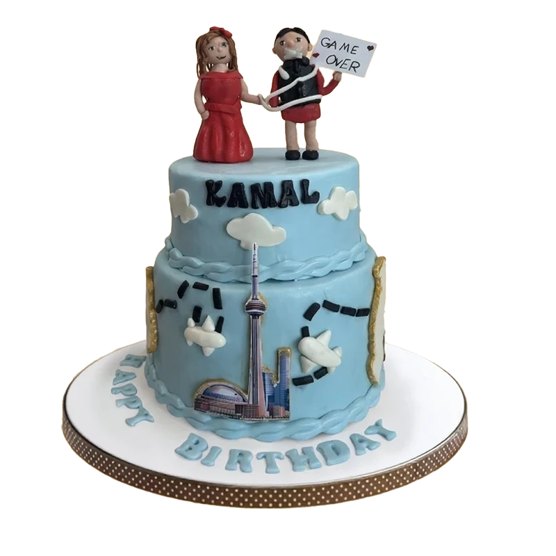 Two-tier blue Toronto skyline birthday cake with CN Tower, clouds, and bride groom figures