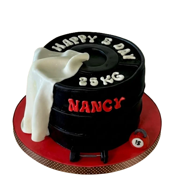 Gym-themed birthday cake shaped like a black 25kg weight plate with white towel drape