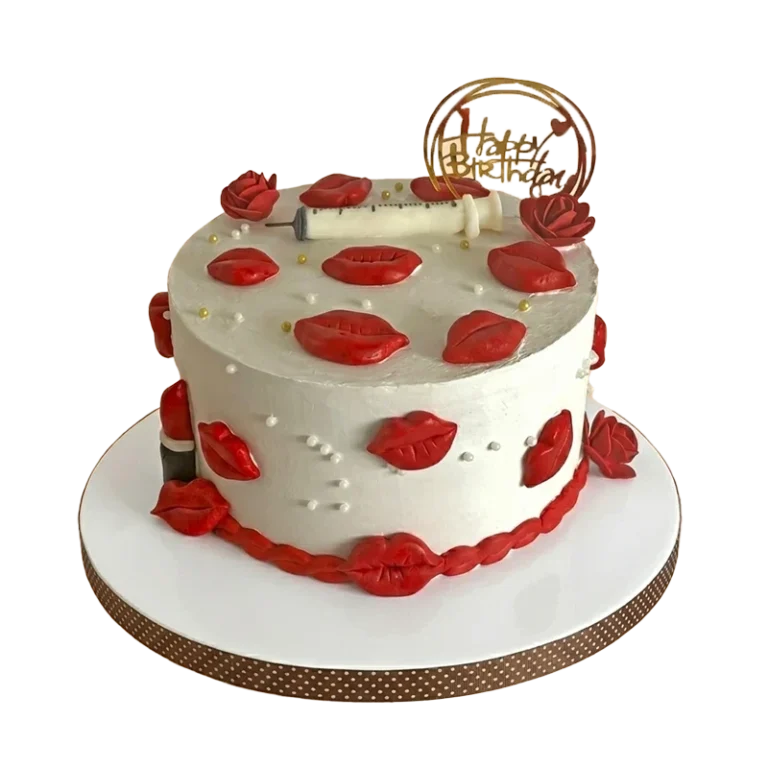 White birthday cake covered with red lips and roses, syringe accent, and gold hoop topper