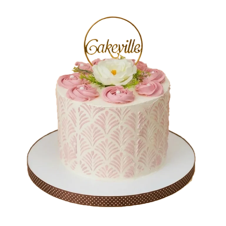 Pink floral stencil cake with pink rosettes, white peony, and gold Cakeville hoop topper