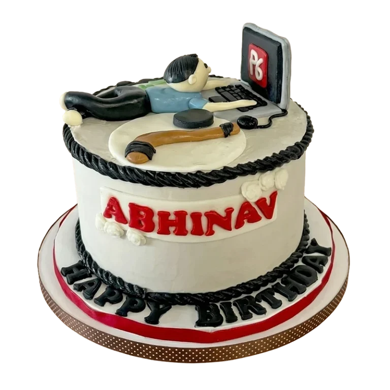 Two-tier birthday cake with man sleeping at laptop figure topper and name inscription