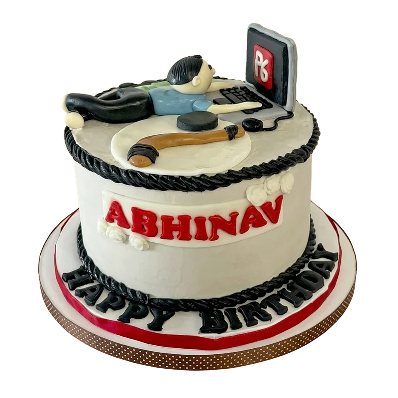 Two-tier birthday cake with man sleeping at laptop figure topper and name inscription