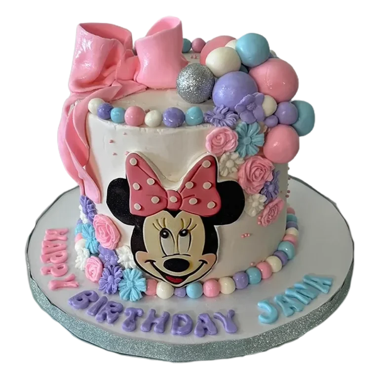 Whimsical Minnie Mouse birthday cake with pastel balloon clusters, pink bow, and floral decorations
