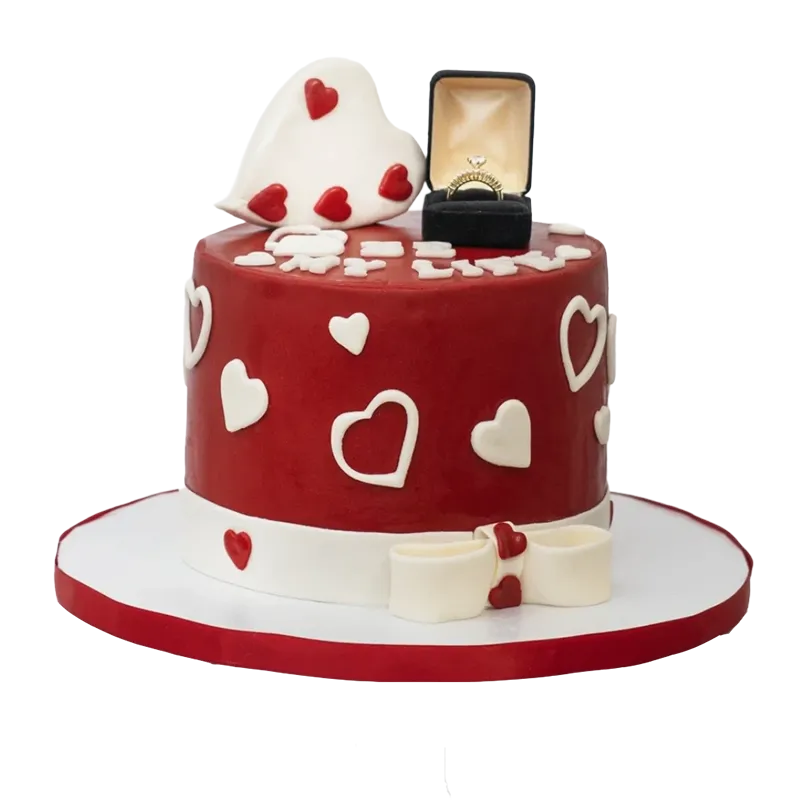 Red anniversary proposal cake with white hearts, engagement ring box topper, and bow at base