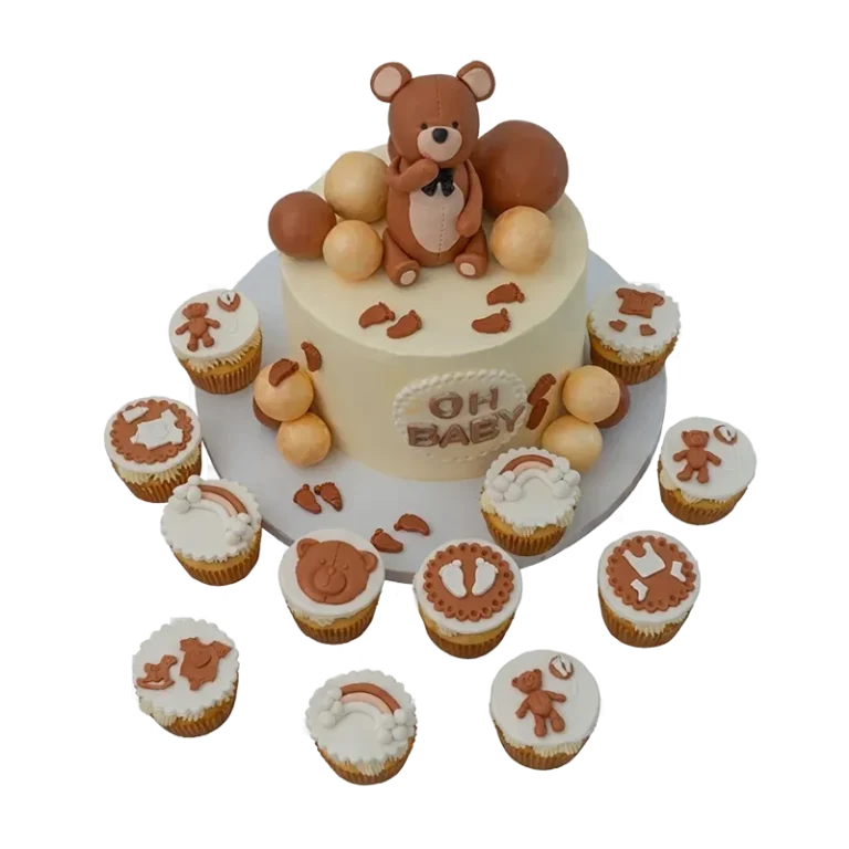 Baby shower cake with teddy bear topper and bear-themed cupcakes