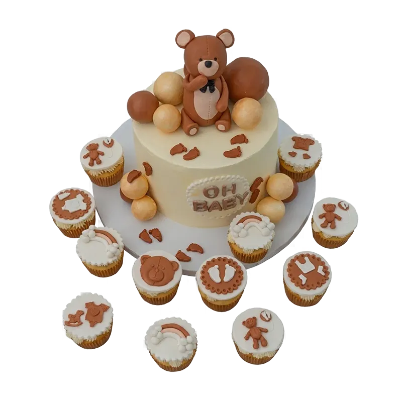 Baby shower cake with teddy bear topper and bear-themed cupcakes