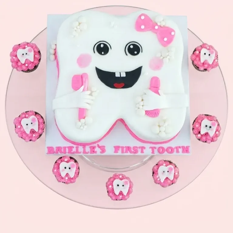Radiant Smile first tooth cake set with tooth-shaped cake, pink bow, and matching tooth cupcakes
