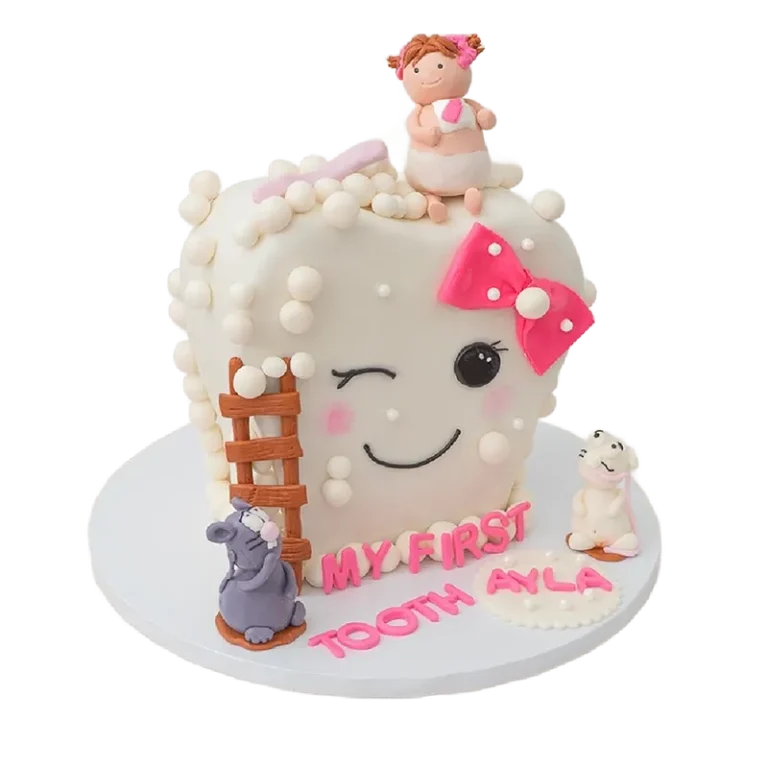 First tooth celebration cake shaped as smiling tooth with pink bow, baby girl, and mouse figurines