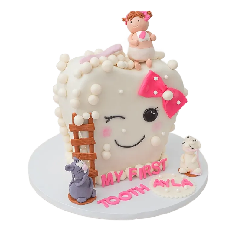 First tooth celebration cake shaped as smiling tooth with pink bow, baby girl, and mouse figurines