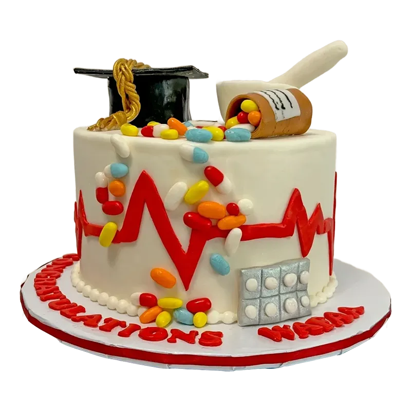 Two-tier classroom graduation cake with ABC letters, school supplies, and graduation cap topper