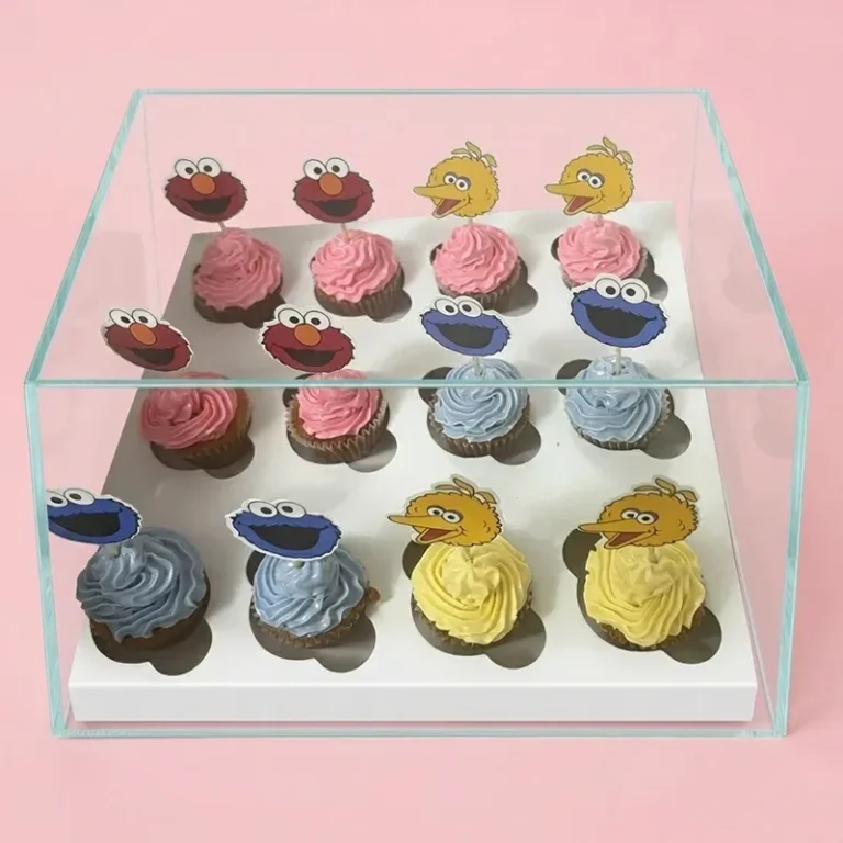 Sesame Street cupcakes with Elmo, Big Bird, and Cookie Monster toppers in pink, yellow, and blue