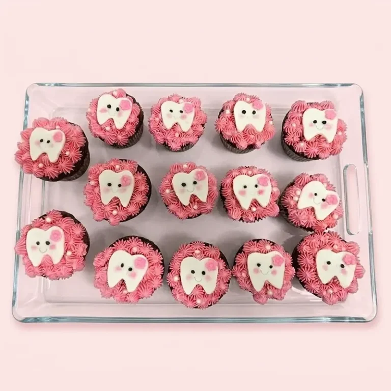 Sweet Smiles first tooth cupcakes with pink frosting and smiling white tooth fondant toppers