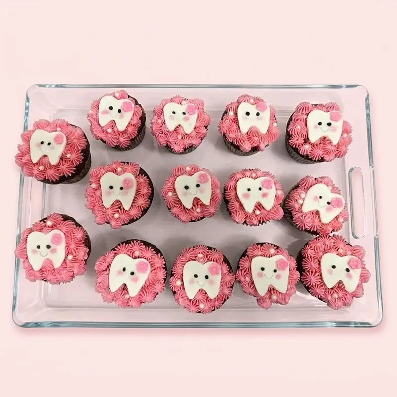 Sweet Smiles first tooth cupcakes with pink frosting and smiling white tooth fondant toppers