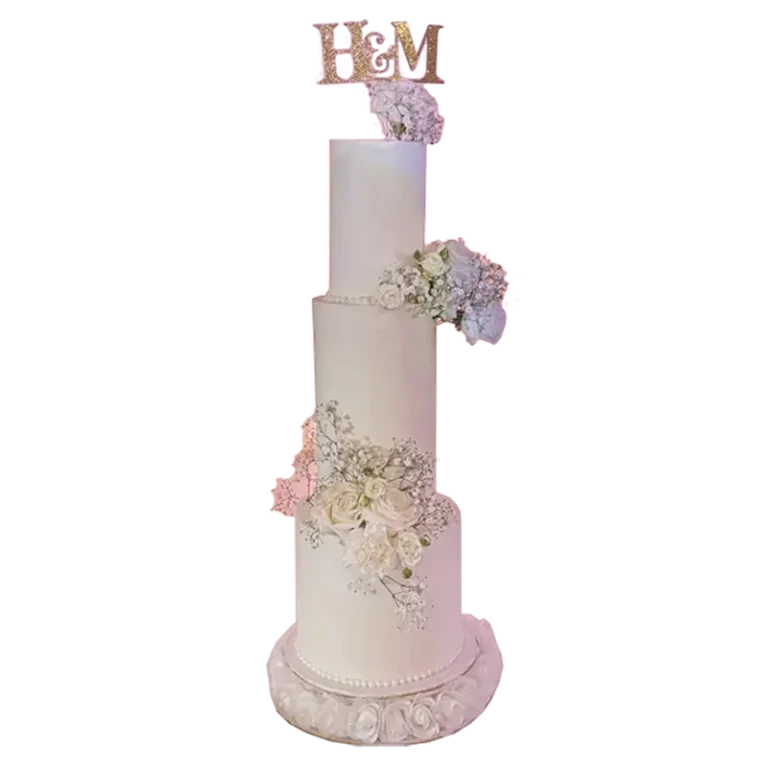 Four-tier ivory wedding cake with cascading pink and lavender flowers and monogram topper
