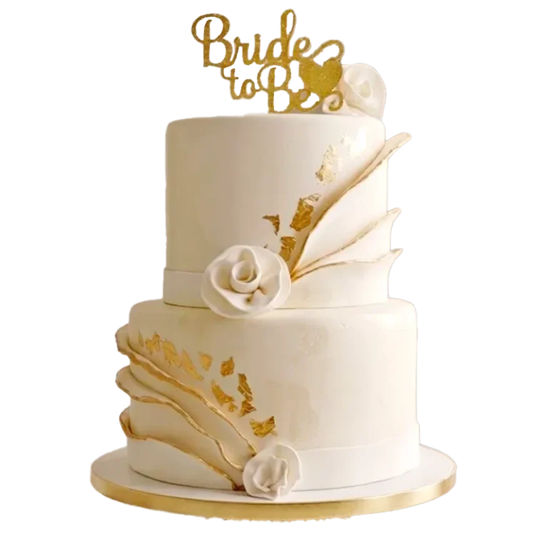 Two-tier white wedding cake with gold leaf, white rose, and Bride to Be topper