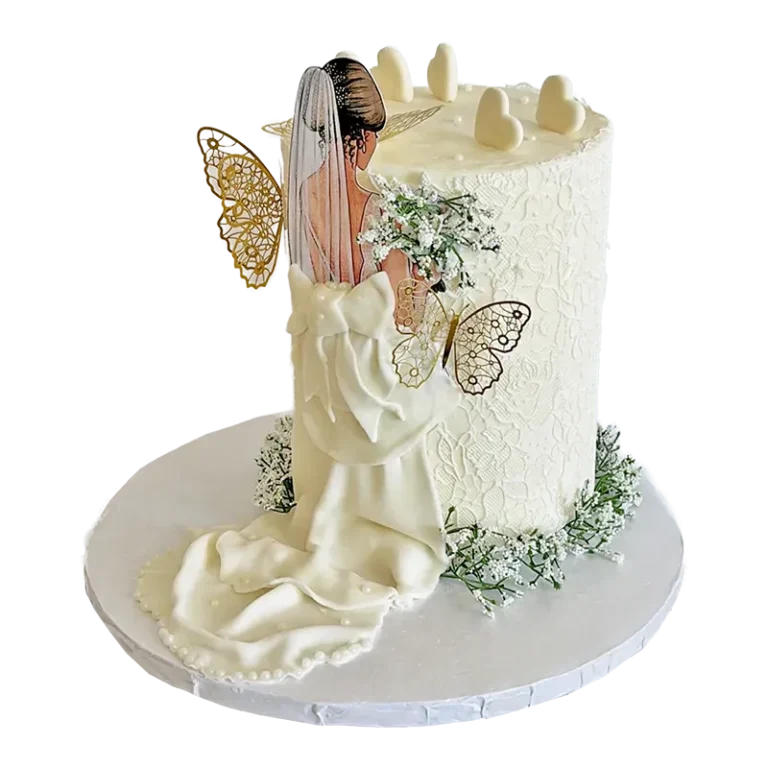White wedding cake with bride figure, gold butterfly accents, and lace texture