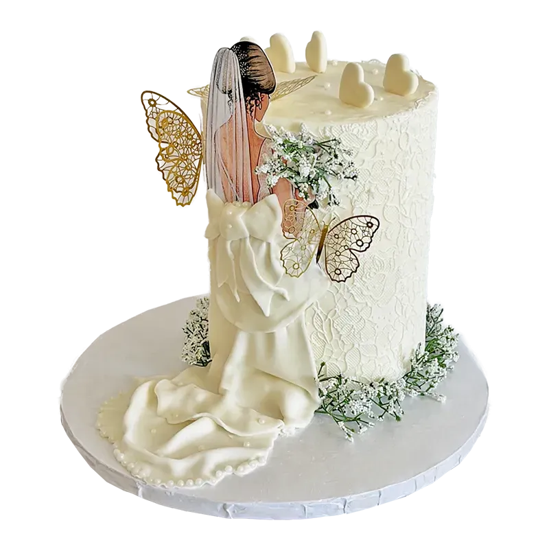 White wedding cake with bride figure, gold butterfly accents, and lace texture