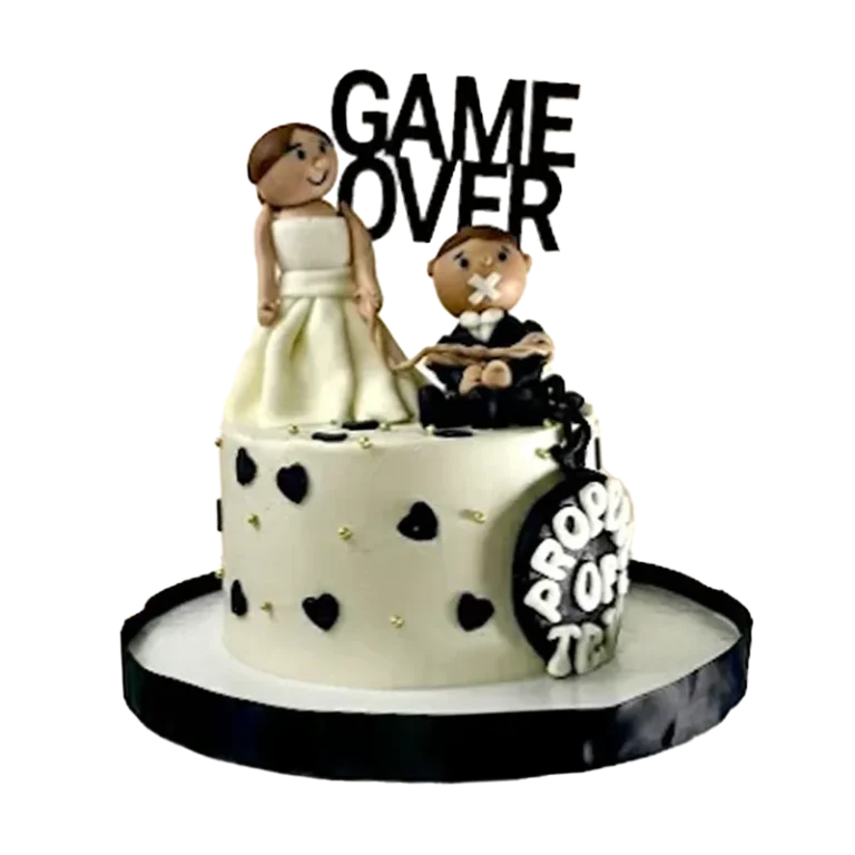 Black and white wedding cake with bride and groom figures, black hearts, and Game Over topper
