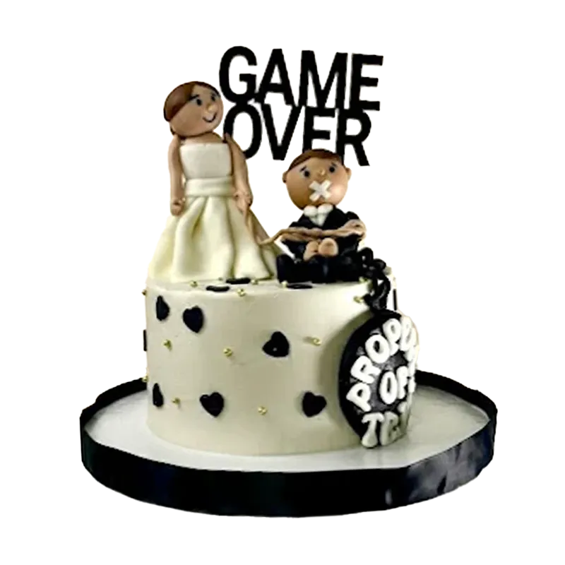 Black and white wedding cake with bride and groom figures, black hearts, and Game Over topper