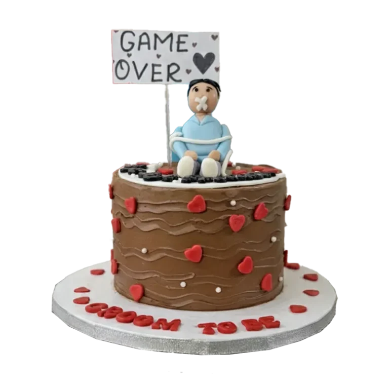 Chocolate bachelor cake with tied groom figure, red hearts, and Game Over sign topper