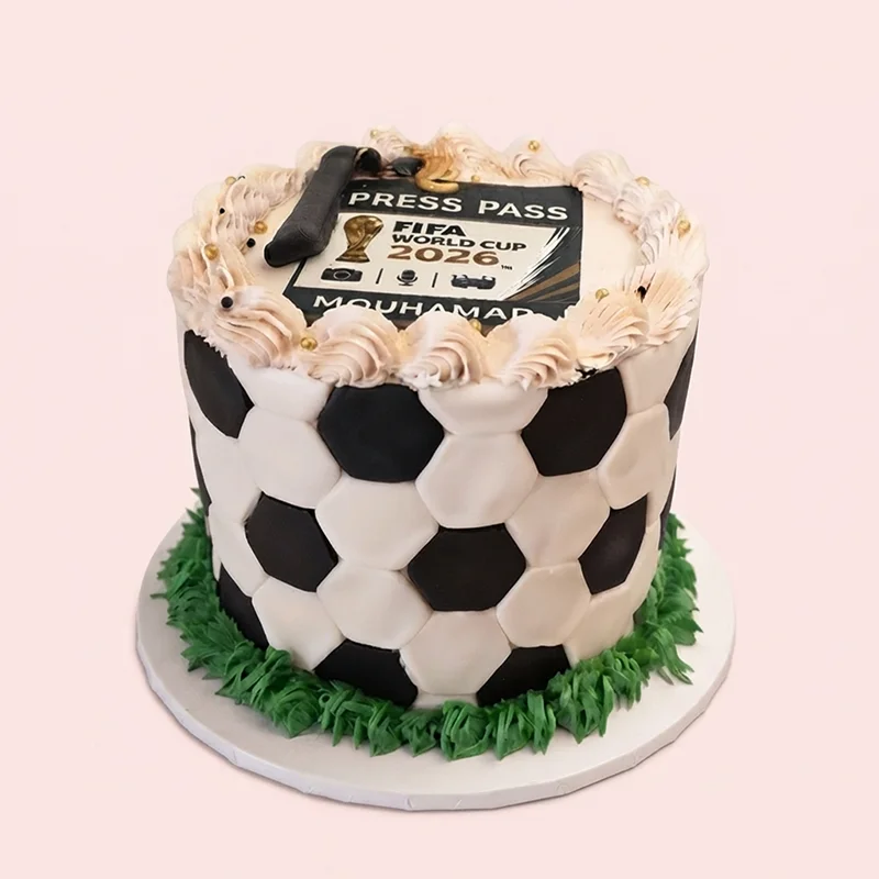 Black and white soccer ball themed birthday cake with press pass topper and grass piping by Cakeville Scarborough