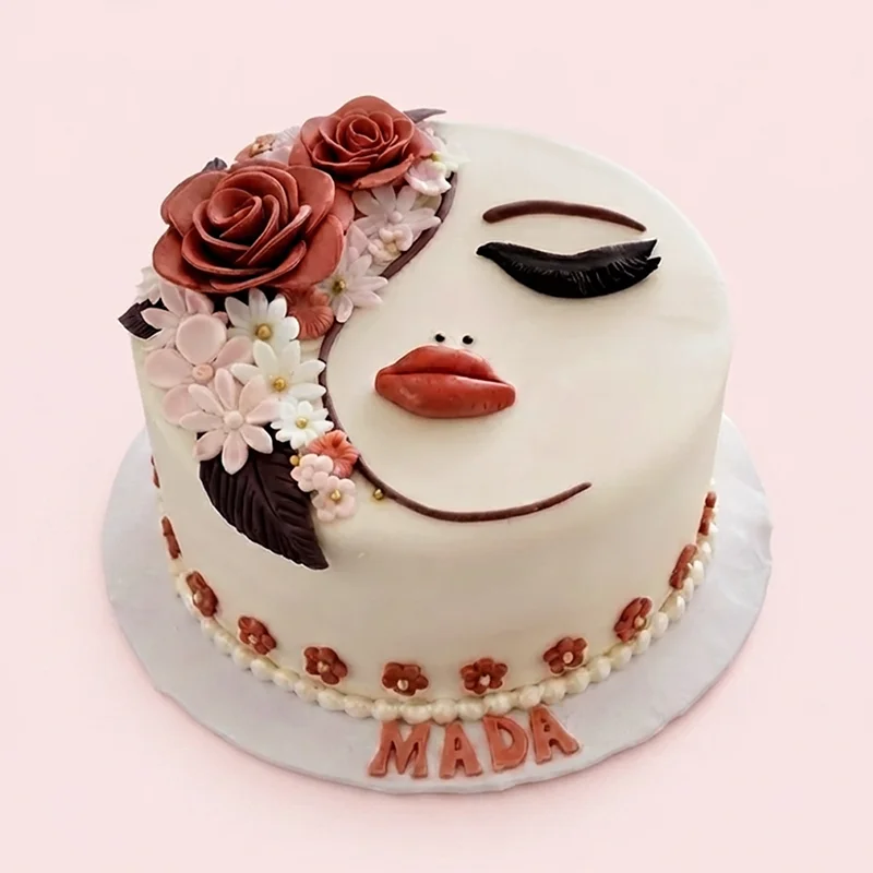 Cream birthday cake with sculpted lady face and dusty rose fondant flowers by Cakeville Scarborough