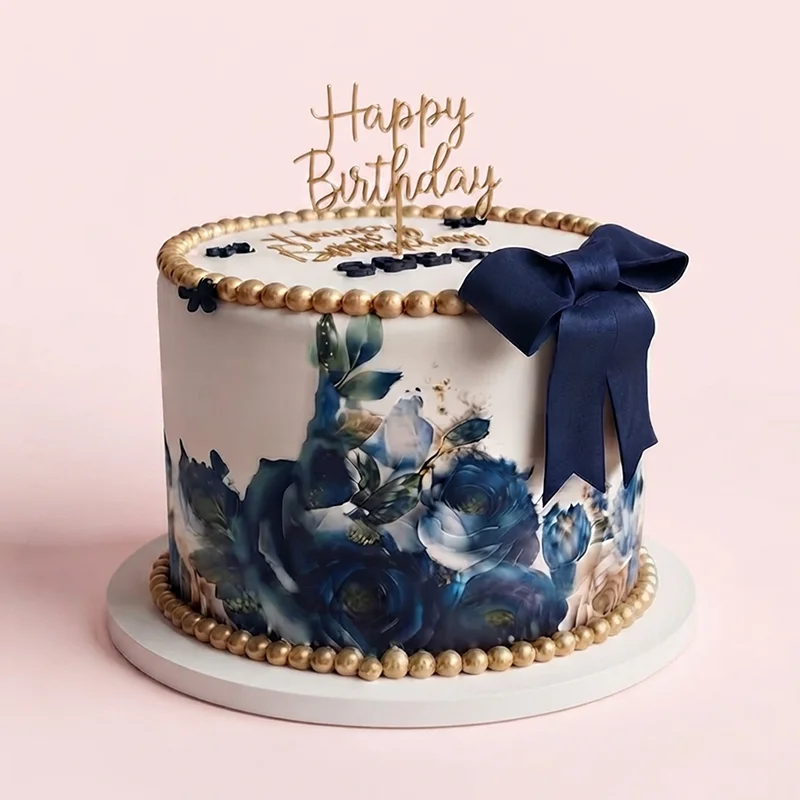 White birthday cake with navy watercolour roses, gold pearl border and satin bow by Cakeville Scarborough