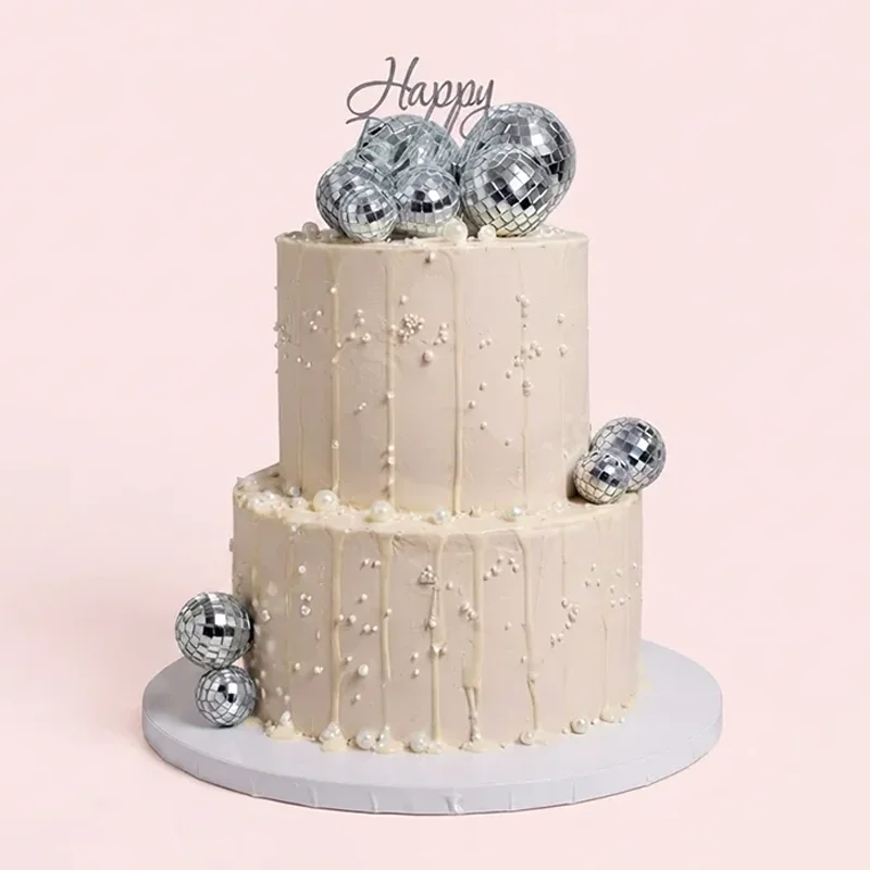 Two-tier cream birthday cake with white drip, sugar pearls and disco ball accents by Cakeville Scarborough