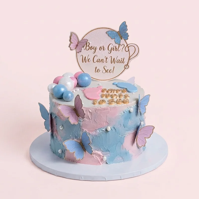 Pink and blue gender reveal cake with butterflies, baby footprints and gold lettering by Cakeville Scarborough