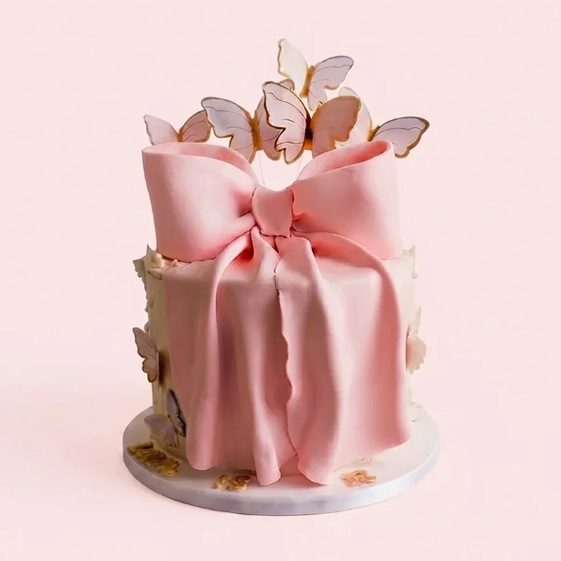 Pink draped bow cake with gold edged butterfly toppers by Cakeville Scarborough