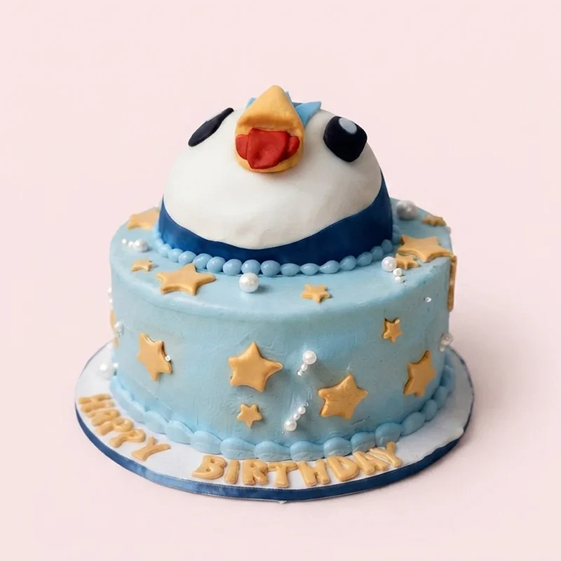 Blue birthday cake with penguin character topper and gold stars by Cakeville Scarborough