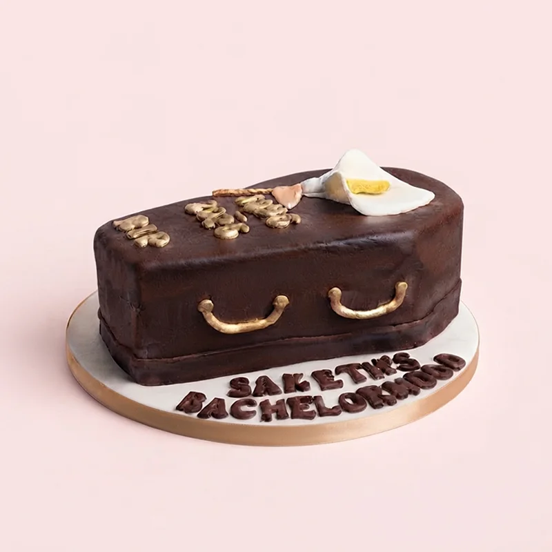 Dark chocolate bachelor party novelty coffin cake with gold detailing by Cakeville Scarborough